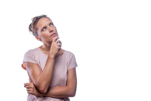 Front view of a pensive green-eyed woman standing looking up on a white background with copy space.