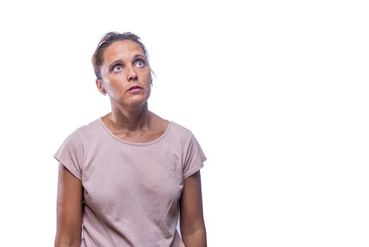 Front view of a shocked green-eyed woman looking up on a white background with copy space.