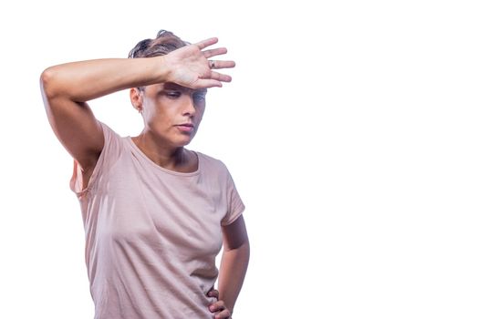 Front view of a tired woman with her hand on her forehead on a white background with copy space.