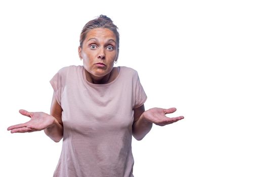 Front view of a green-eyed woman looks doubtfully on a white background with copy space.