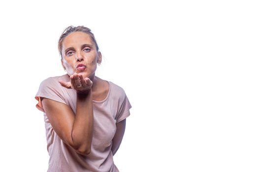 Front view of a green-eyed woman sending air kiss on a white background with copy space.