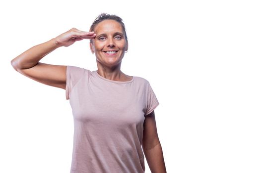 Front view of a green-eyed woman giving a military salute on a white background with copy space.