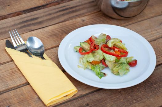 fresh salad of zucchini paprika avocado and green lettuce on a wooden table. High quality photo