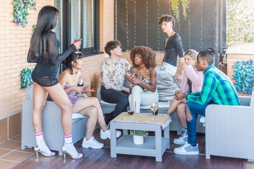 Full length view of a group of a multi-ethnic friends celebrating New Year's Eve on a terrace at day.