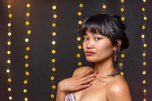 Portrait of an asian young woman posing and looking at camera with a blurred light background with copy space