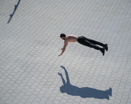 A man doing push-ups with flying outdoors