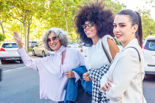 three businesswomen waiting for a taxi after a working day, horizontal portrait