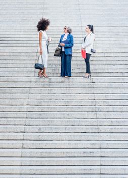 co-workers talking in the middle of a granite staircase. Background with steps aligned