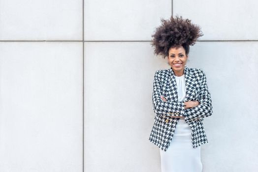 Afro-haired businesswoman posing facing the camera, copy space on the left