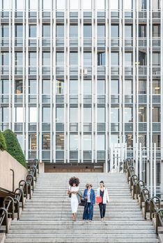 women entrepreneurs walking down the stairs after work, vertical background