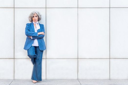 serious business manager waiting leaning on the wall, portrait view