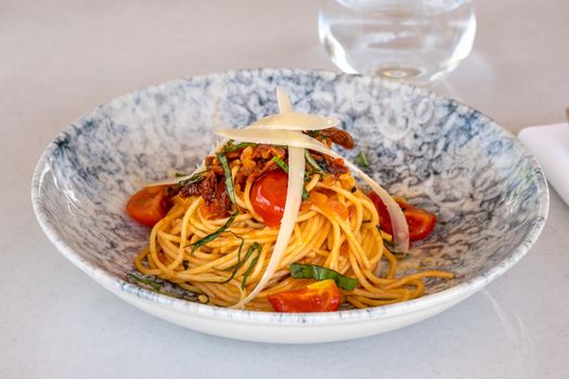 Spaghetti with a spicy sauce, chili pepper and grated parmesan cheese