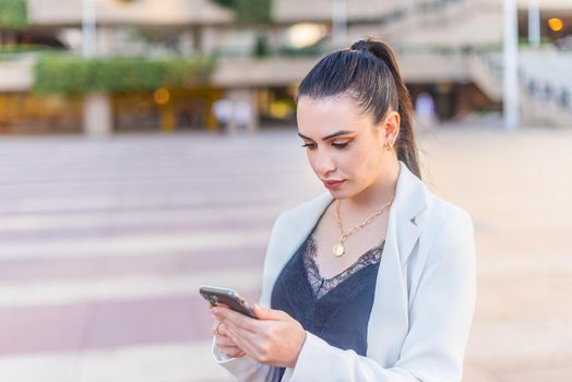 elegant woman typing on her mobile phone. Horizontal blurred background