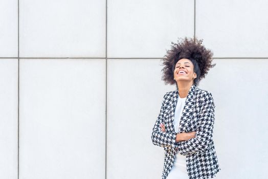 african mid adult woman laughing wearing a plaid jacket and a white dress, cut out view