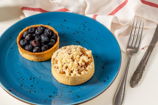 Freshly baked single portion blueberry and apple pie on a blue porcelain plate