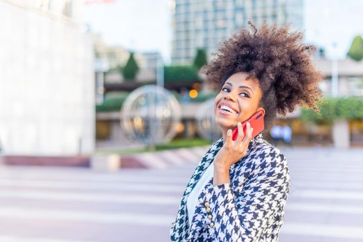 african woman having fun with what her contact is telling her on the phone