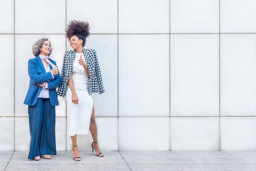 two women laughing while enjoying a break from work, copy space in the right