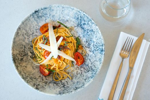 Spaghetti with a spicy sauce, chili pepper and grated parmesan cheese