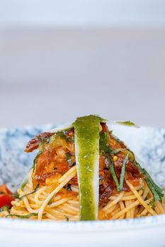 Spaghetti with a spicy sauce, chili pepper and grated parmesan cheese