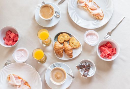 Top view of a full breakfast for two served at a table in a hotel dining room. Concept of breakfast in hotel.