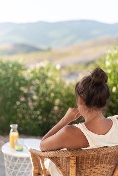 Vertical image of an adult woman on her back in her rural home enjoying the outdoors overlooking the hills and mountains of Almeria, Spain.