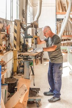 Man working with precision drilling metal in a factory, vertical