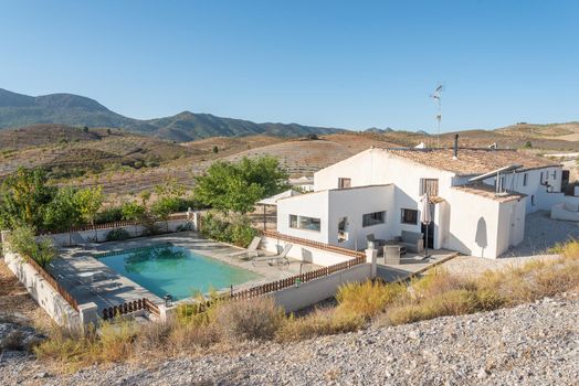 A rural hotel with swimming pool with hills and mountains located in Almeria, Spain. Concept of tourism.