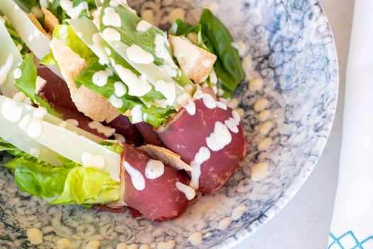 Bacon and cheese salad on a white porcelain plate