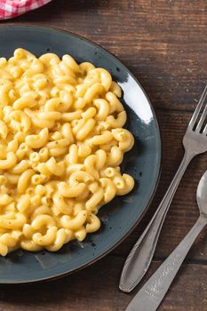 Delicious Mac n Cheese or macaroni and cheese on a black porcelain plate