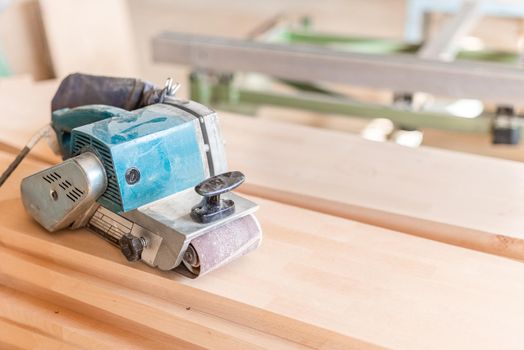 hand sander on a wooden board, blurred background