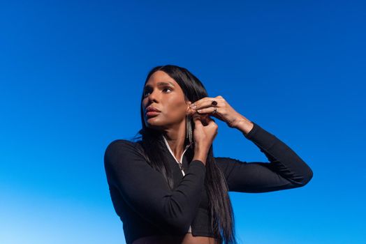 Portrait of a transsexual woman wearing an earring while looking to the side during sunset outside