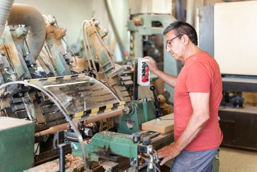 Man working turning a wooden baluster. Manufacturing process, machinery, horizontal