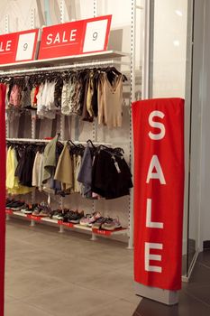 Sale sign on red entrance gates or sensor security panels of fashion shop clothing store, black friday sale shopping concept, seasonal offer promo, vertical image