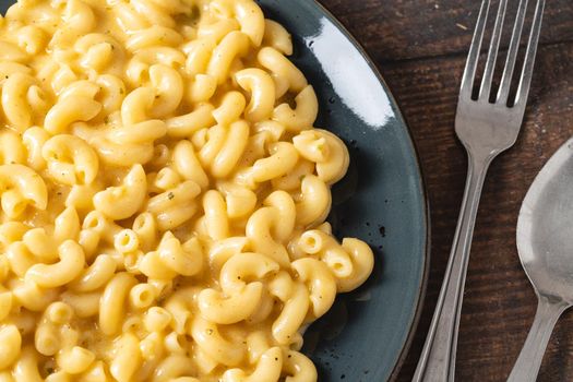 Delicious Mac n Cheese or macaroni and cheese on a black porcelain plate