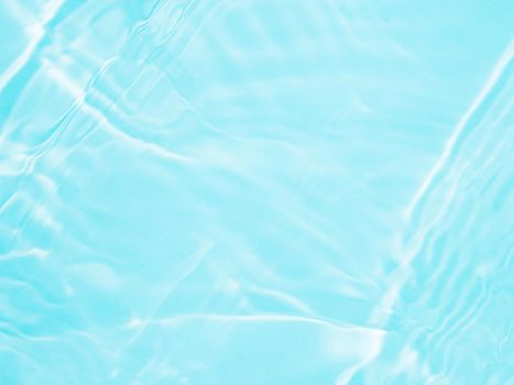 Ripple water texture on blue pool background. Shadow of water on sunlight. Mockup for product, spa or travel background. Marble blue water surface as wallpaper background