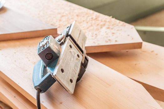 Hand planer over wooden boards, horizontal close-up view