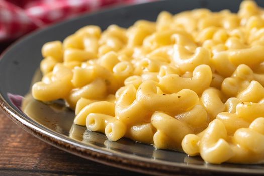 Delicious Mac n Cheese or macaroni and cheese on a black porcelain plate