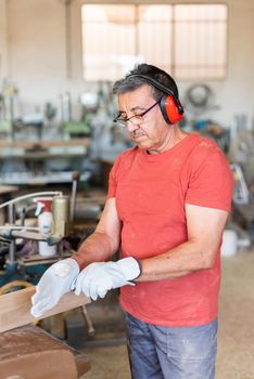 adult man with red t-shirt and glasses getting ready to work in a factory, vertical