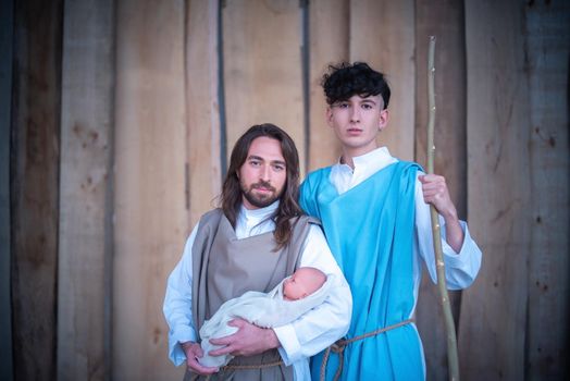 Portrait of homosexual men facing the camera while representing two biblical characters in a crib