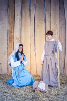 Vertical photo of the christmas crib with transgender people representing a scene of Mary and Joseph