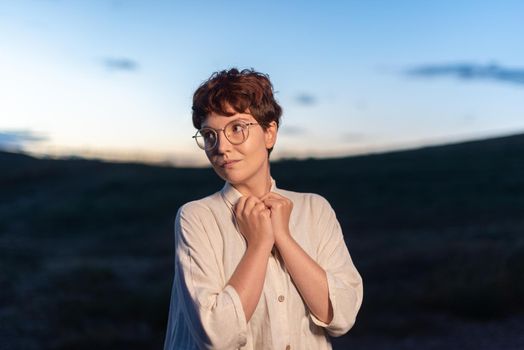 Portrait with copy space at dusk of a non-binary gender woman looking at the side outdoors