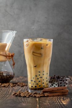 Bubble tea with coffee and chocolate in glass cup on dark background.