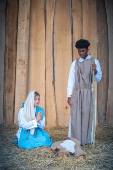 Vertical nativity scene with multi-ethnic characters with caucasian virgin mary and black joseph
