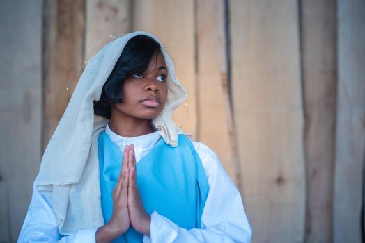 Photo with copy space of a black virgin mary representation praying in a crib