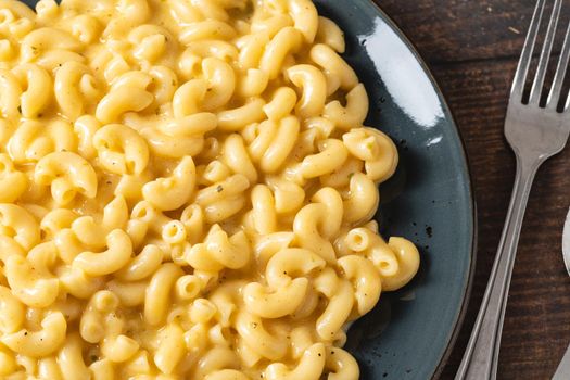 Delicious Mac n Cheese or macaroni and cheese on a black porcelain plate