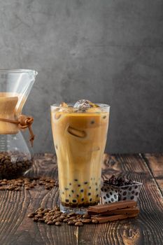 Bubble tea with coffee and chocolate in glass cup on dark background.