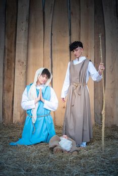 Vertical nativity scene with androgynous persons representing the virgin mary and joseph