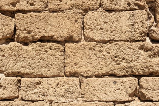 Closeup of full frame texture of aged stone brick wall of ancient castle of Citadel of Almeria city in Spain in sunny day