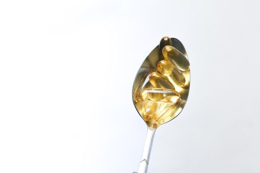 fish oil supplement on a spoon on isolated on white ,