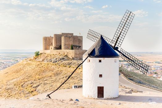 Restored antique windmill and a castle on a hill in Toledo, Spain